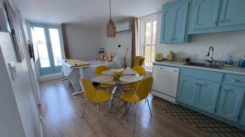 a kitchen with blue cabinets and a table and chairs at Propre Confortable Près des services in Saint-Joseph-de-Beauce