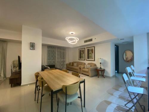 a living room with a wooden table and chairs at Sea View - 2BHK - Al Reem Island 6ppl Free Transportation from AD Airport in Abu Dhabi