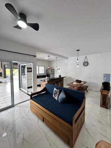 a living room with a blue couch and a kitchen at refúgio urbano in Nova Odessa