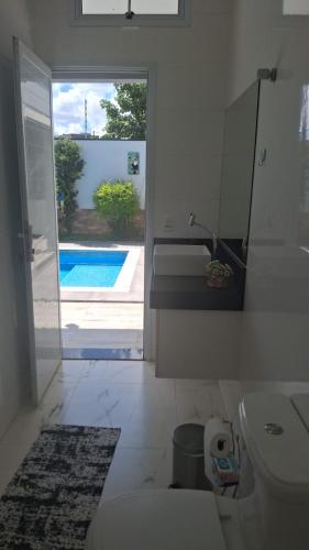a bathroom with a toilet and a view of a pool at refúgio urbano in Nova Odessa