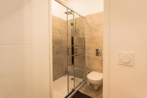 a bathroom with a toilet and a glass shower at Yassam -Le Studio 301 in Saint-Brieuc