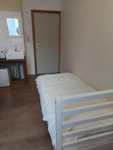 una camera da letto con un letto bianco e un lavandino di Deurne ad Anversa