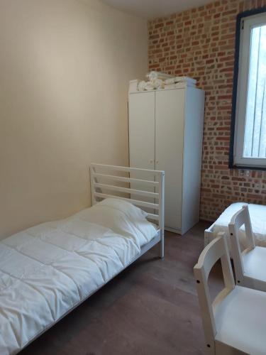 una piccola stanza con un letto e un frigorifero di Deurne ad Anversa