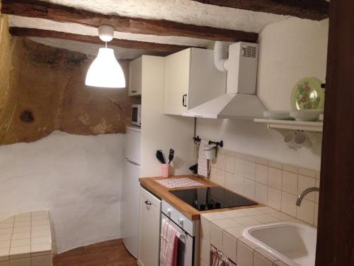 una pequeña cocina con armarios blancos y fregadero en El Encanto de Mora, en Mora de Rubielos