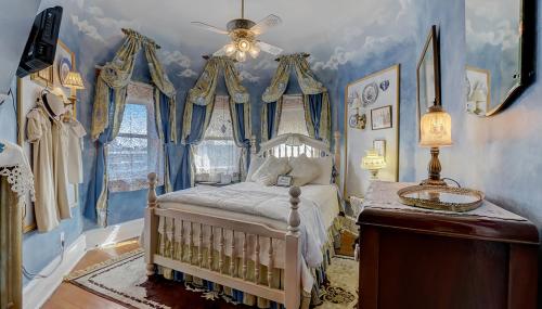 a bedroom with a bed with blue walls and a ceiling at Schuster Mansion Bed & Breakfast in Milwaukee