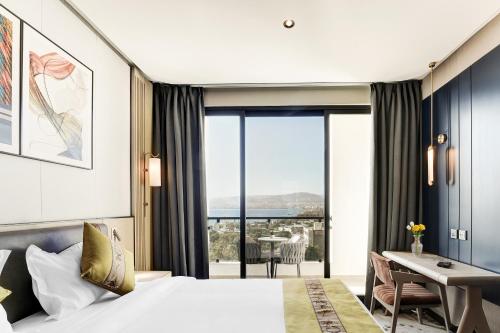 a hotel room with a bed and a view of the ocean at April Hotel in Aqaba