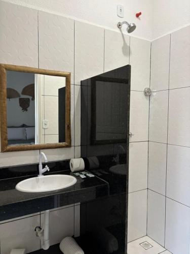 a bathroom with a sink and a mirror at Pousada Flor De Prado in Prado