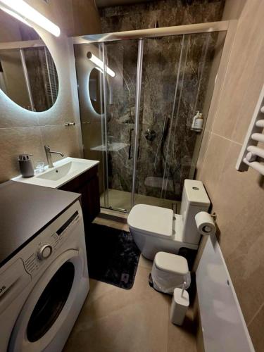 a bathroom with a shower and a toilet and a sink at Hermes Modern Apartment in Alexandroupoli