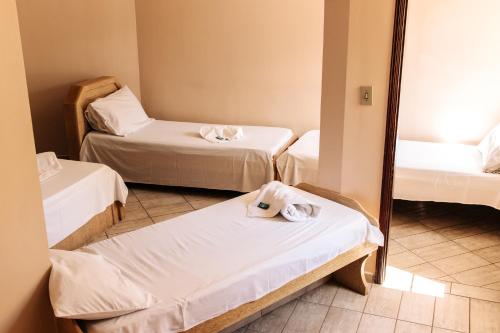 a room with three beds and a mirror at Niv's Hotel in Monte Sião