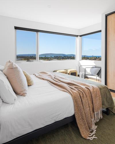 a bedroom with a large bed and large windows at The Lookout, Albany Holiday House in Albany