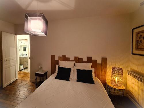 a bedroom with a large bed and a pendant light at Maison tout confort avec jardin - CHANTILLY, SENLIS, PARC ASTERIX, PARIS CDG in Avilly-Saint-Léonard
