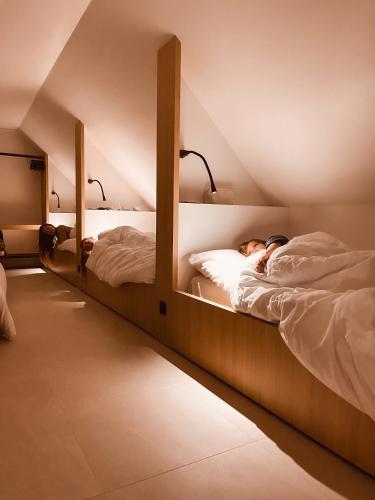 two beds with a person sleeping on them at DOS22 Vakantiewoning I De Haan Wenduine in Zuienkerke