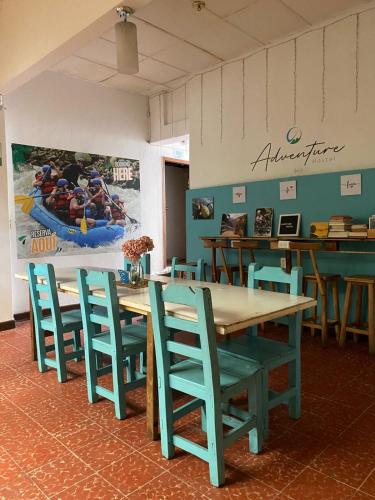 a dining room with tables and chairs and a painting on the wall at ADVENTURE Hostel in San Gil