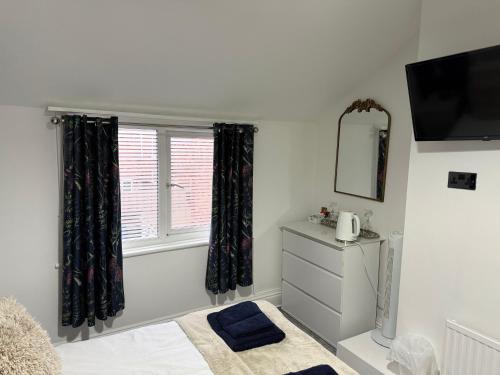 a bedroom with a window and a dresser and a mirror at Rooms at 153 ROOM ONLY in Scarborough