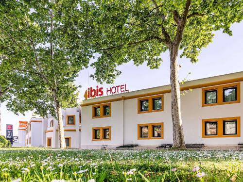 a hotel with trees in front of it at Hotel ibis Evora in Évora
