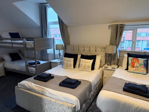 a bedroom with two beds and a bunk bed at Rooms at 153 ROOM ONLY in Scarborough