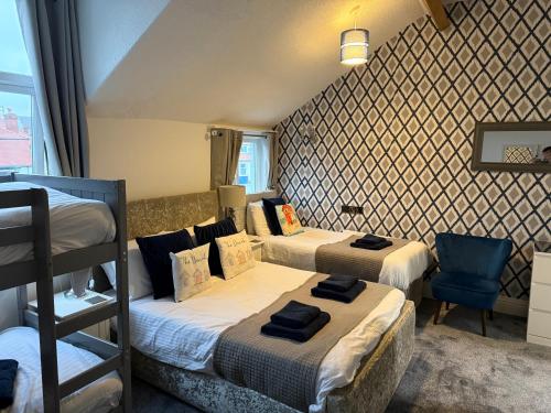 a bedroom with two beds and a chair in it at Rooms at 153 ROOM ONLY in Scarborough
