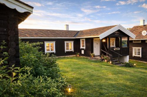 a house with a grass yard in front of it at Traditional timber farm with Sauna & Wi-Fi in Baukål