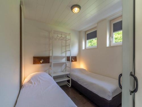 a small room with two beds and a mirror at Bungalow near Dutch Coast with Private Garden in Callantsoog