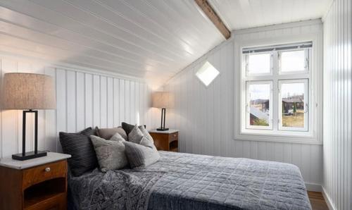 a white bedroom with a bed and a window at Paradis ved Norefjell in Surteberg