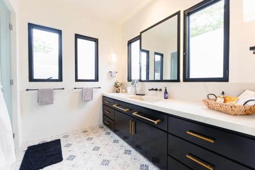 a bathroom with a black vanity and two windows at Villa De Vida Luxury Accomodations in Tangolunda