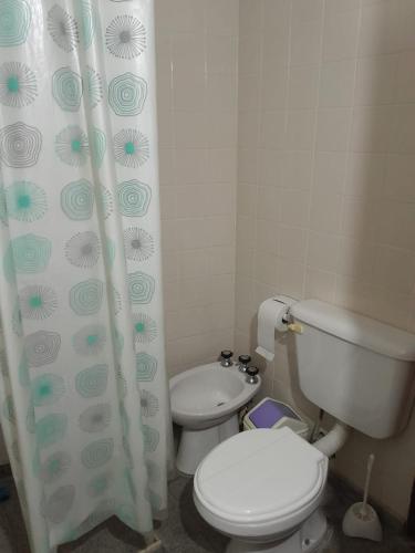 a bathroom with a toilet and a shower curtain at Pura Brisa in Almafuerte