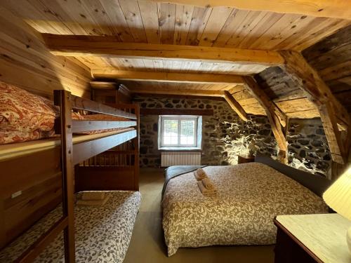 a bedroom with two beds in a room with wooden ceilings at La Grangette de Barbe in Le Béage