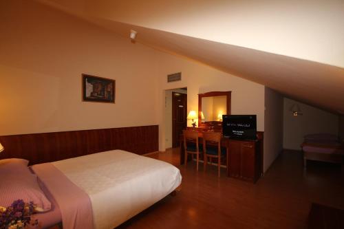 1 dormitorio con 1 cama y escritorio con TV en Villa Koruna - Mali Ston, en Ston
