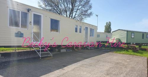 a house with a sign that reads backyard camper conversion at Becky's Caravan at Marton Mere in Blackpool