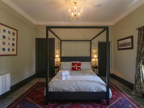 a bedroom with a four poster bed with a chandelier at Bohan Bo in Kilmuckridge