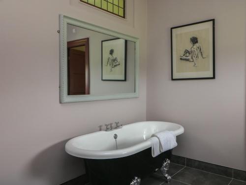 a bathroom with a bath tub and a mirror at Bohan Bo in Kilmuckridge