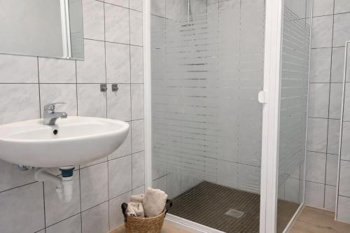 a white bathroom with a sink and a shower at Monteur- und Ferienunterkunft Waghäusel in Waghäusel
