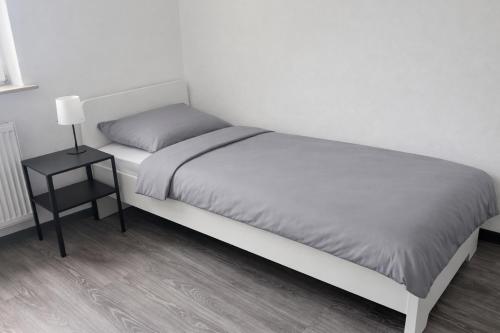 a bed in a room with a side table at Monteur- und Ferienunterkunft Waghäusel in Waghäusel
