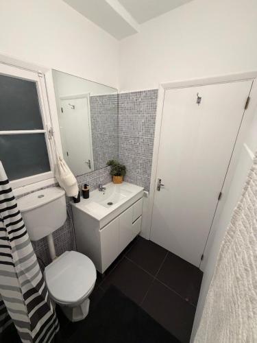 a bathroom with a white toilet and a sink at Casa da Torre in Porto Moniz