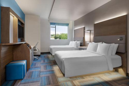 a hotel room with two beds and a television at EVEN Hotel Miami - Airport by IHG in Miami