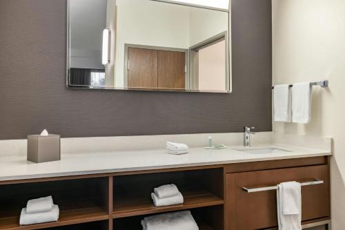 a bathroom with a sink and a mirror at Courtyard Fargo Moorhead, MN in Moorhead