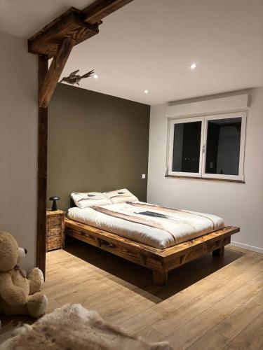 a bedroom with a large wooden bed with a window at Chez David & Magali in Dommartin-lès-Remiremont