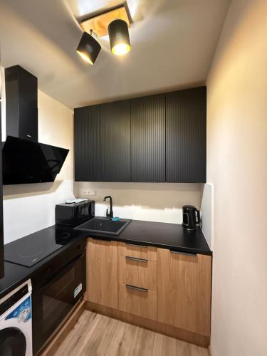 a kitchen with a sink and a black counter top at Apartmán Mia 1 in Liptovský Mikuláš