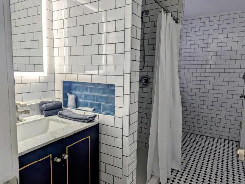 a white bathroom with a sink and a shower at Scotty's Motel in Munising