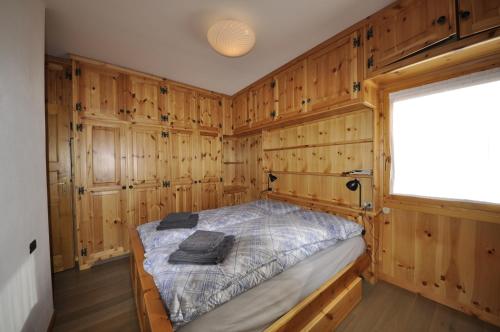 a bedroom with wooden walls and a bed in it at P&P Home in Valdidentro