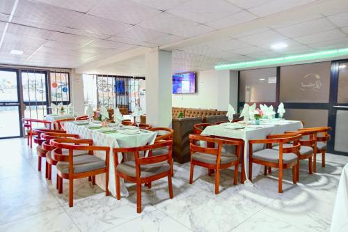ein Speisesaal mit Tischen und Stühlen in einem Restaurant in der Unterkunft Helena Home - Kribi in Kribi