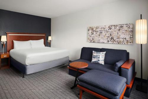 a hotel room with a bed and a couch at Courtyard Fort Myers at I-75 and Gulf Coast Town Center in Estero