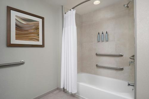 a bathroom with a tub and a shower with a shower curtain at Courtyard Fort Myers at I-75 and Gulf Coast Town Center in Estero