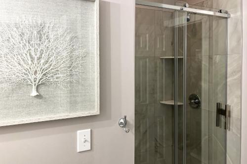 a shower in a bathroom with a picture of a tree at Myrtle Beach Condo: Golf Course + Pool View! in Myrtle Beach