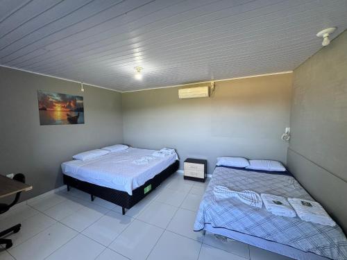a room with two beds in a room at Pousada Bonetti Quarto 1 in Santa Rosa