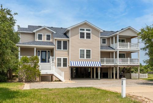 a large house with balconies and a yard at Beach Cabana - Southern Shores, 6 En-Suites, Elevator, Pool, Cabana Bar, Hot Tub, Game Room in Southern Shores
