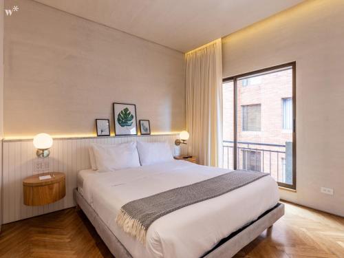a bedroom with a large bed and a large window at Palace by Wynwood House in Bogotá
