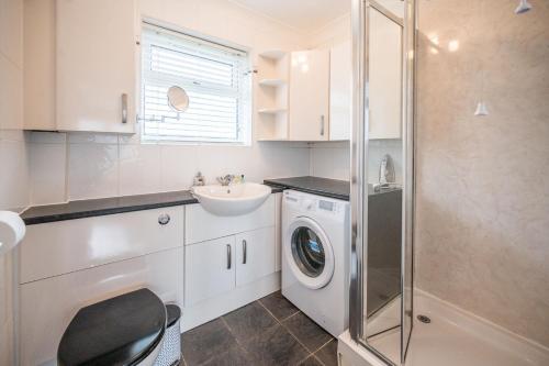 a bathroom with a washing machine and a sink at 100 Waterside Park in Corton