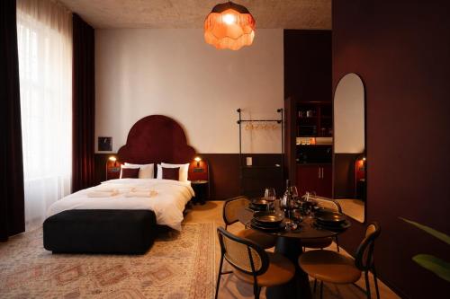 a bedroom with a bed and a table and chairs at Maroon & Moss Residence in Budapest