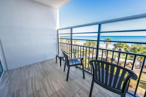 two chairs on a balcony with a view of the ocean at Oceanfront Convenience on Lower Floor, Heated Pool in Myrtle Beach